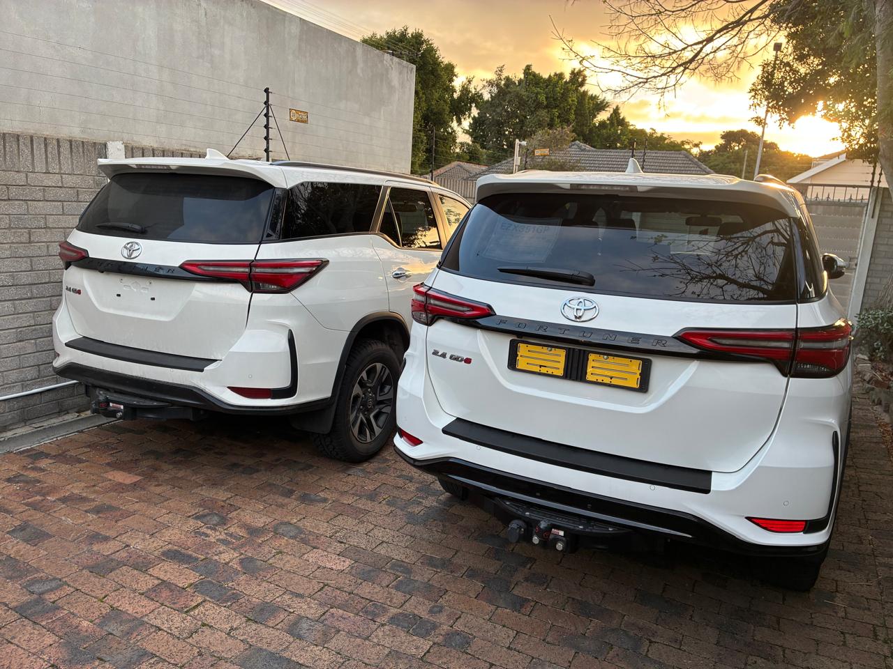 Two i-Drive Toyota Fortuner SUVs parked at sunset